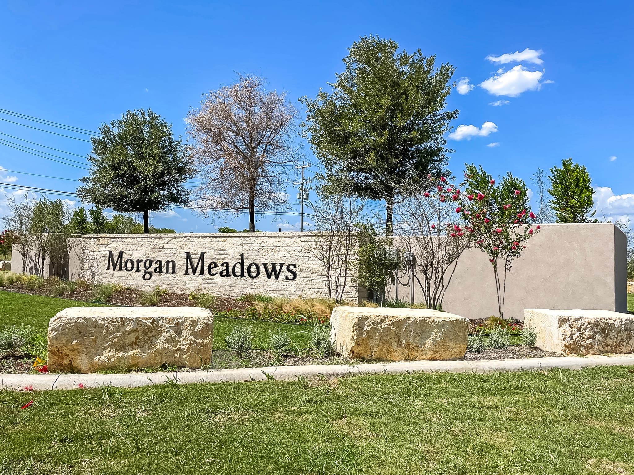 entrance with a stone sign & trees