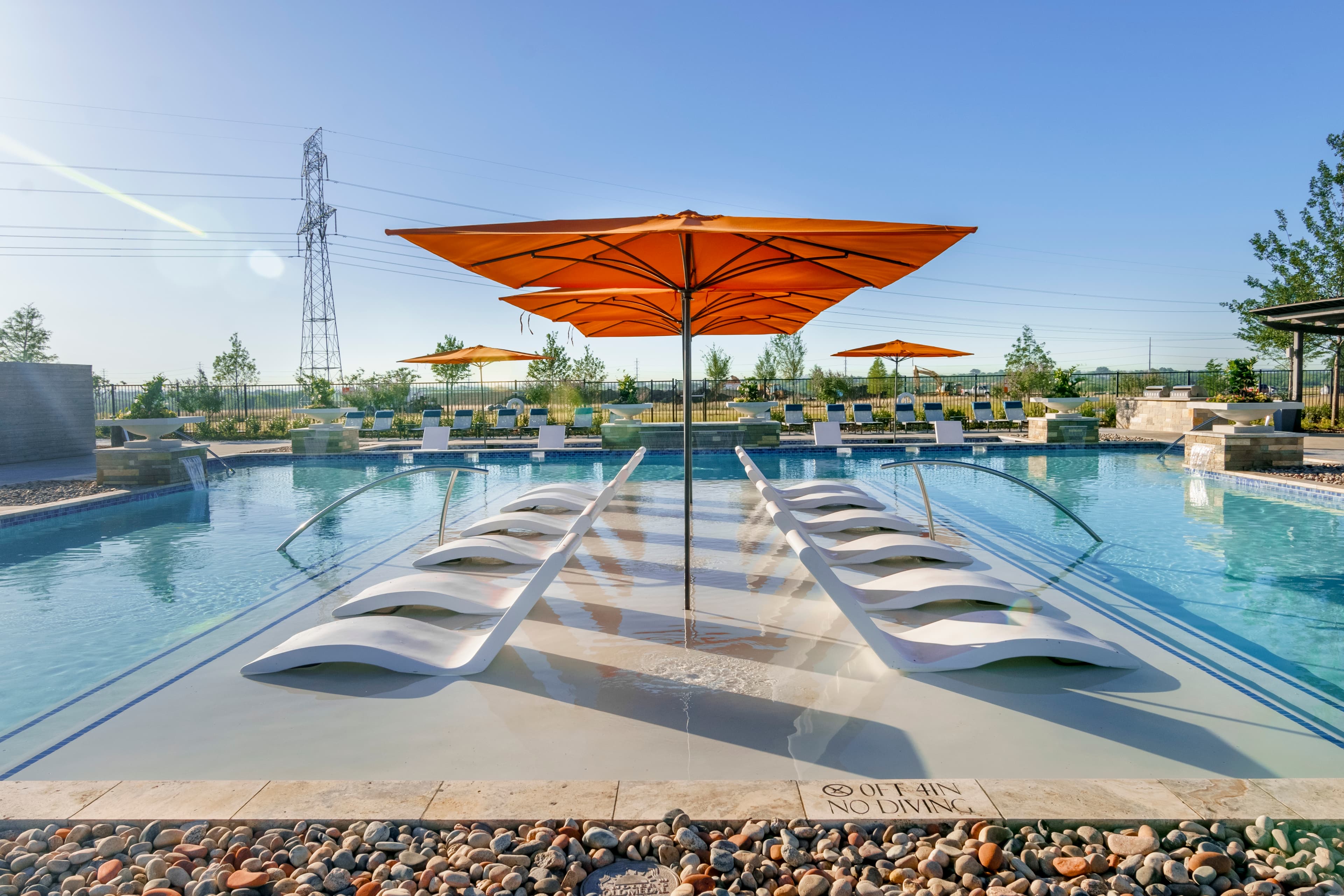 community pool with lounge changes and umbrellas