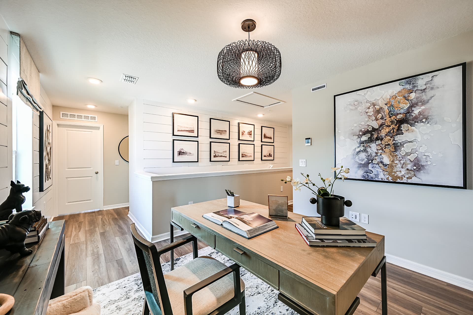 loft with desk, chair, and wall art