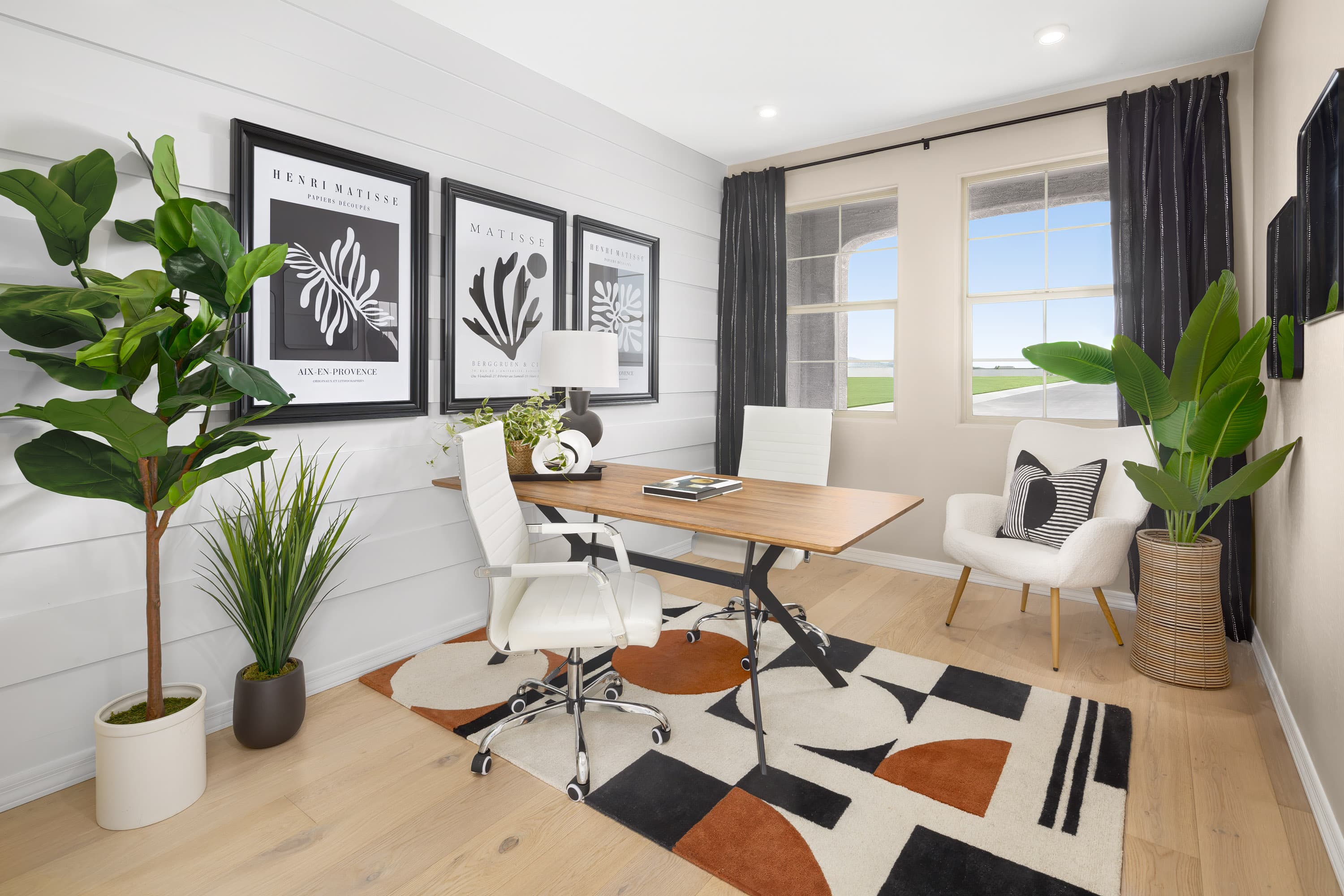 colorful rug with a desk, chairs, and artwork