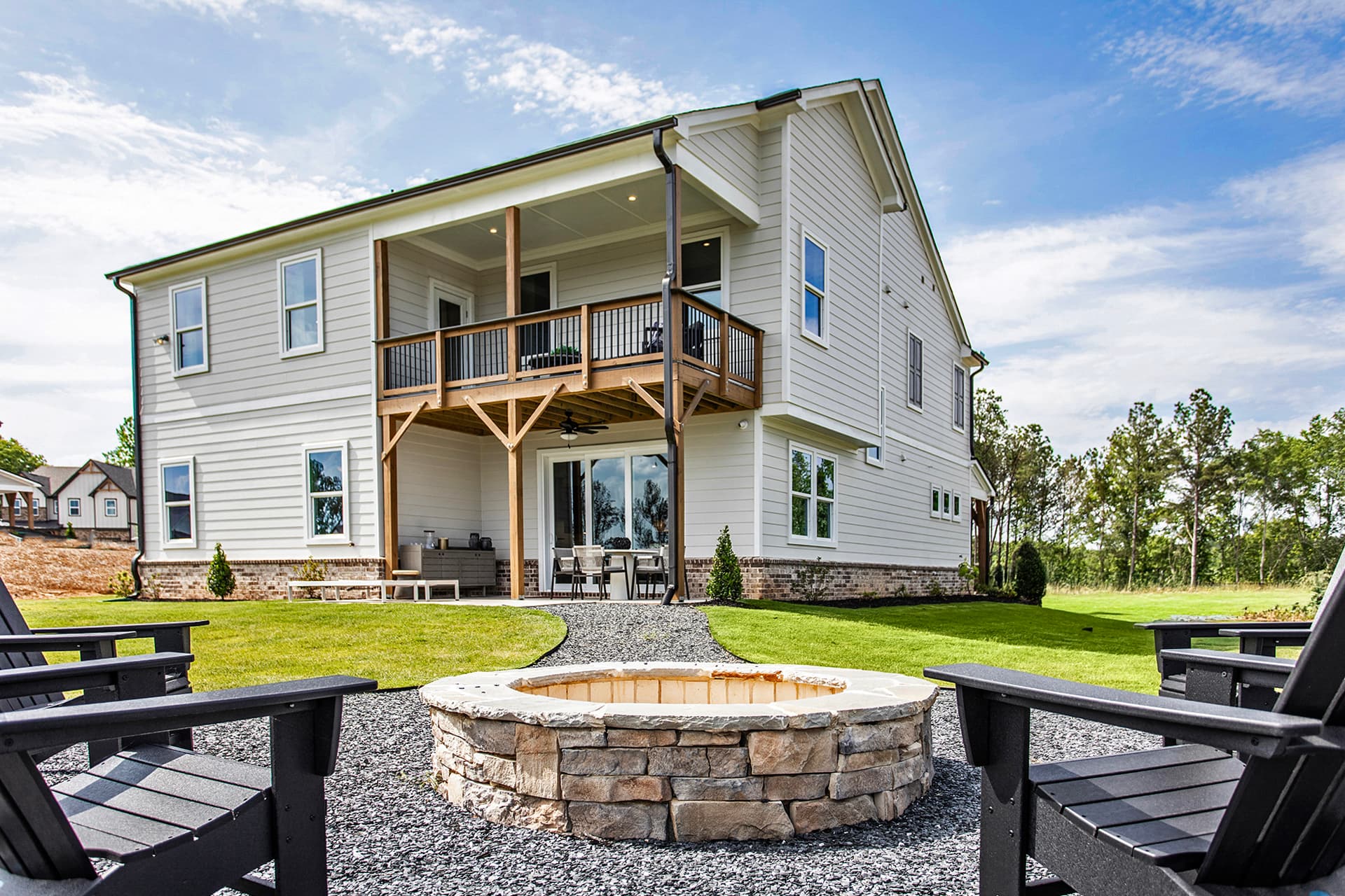 back of 2-story home with covered patio & firepit