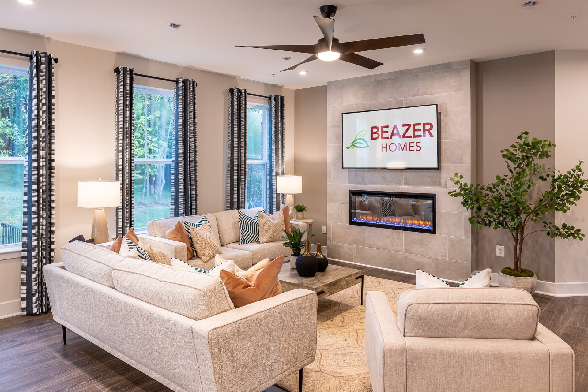 great room with beige couches and a fireplace