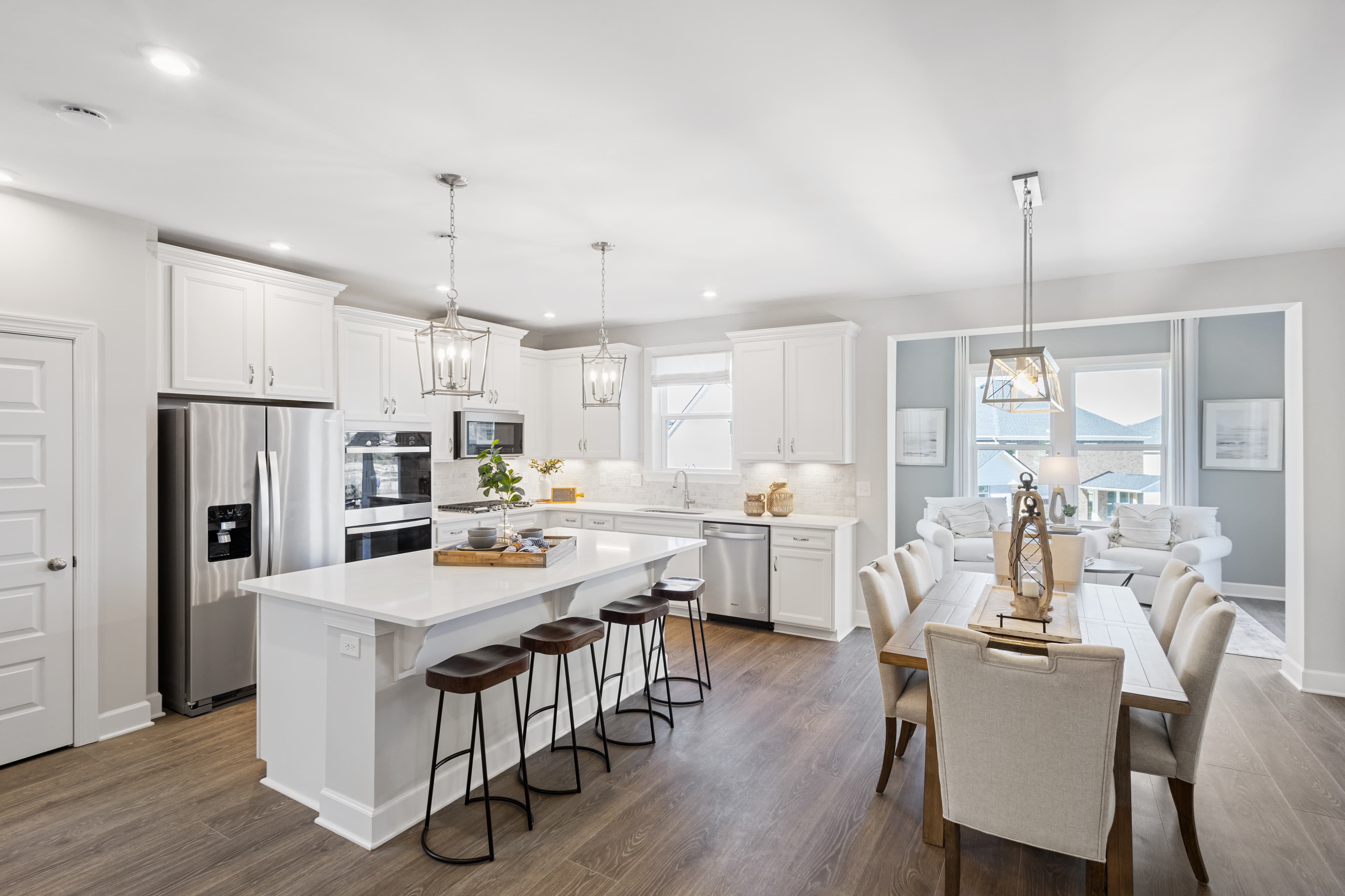 white kitchen with island, and dining area