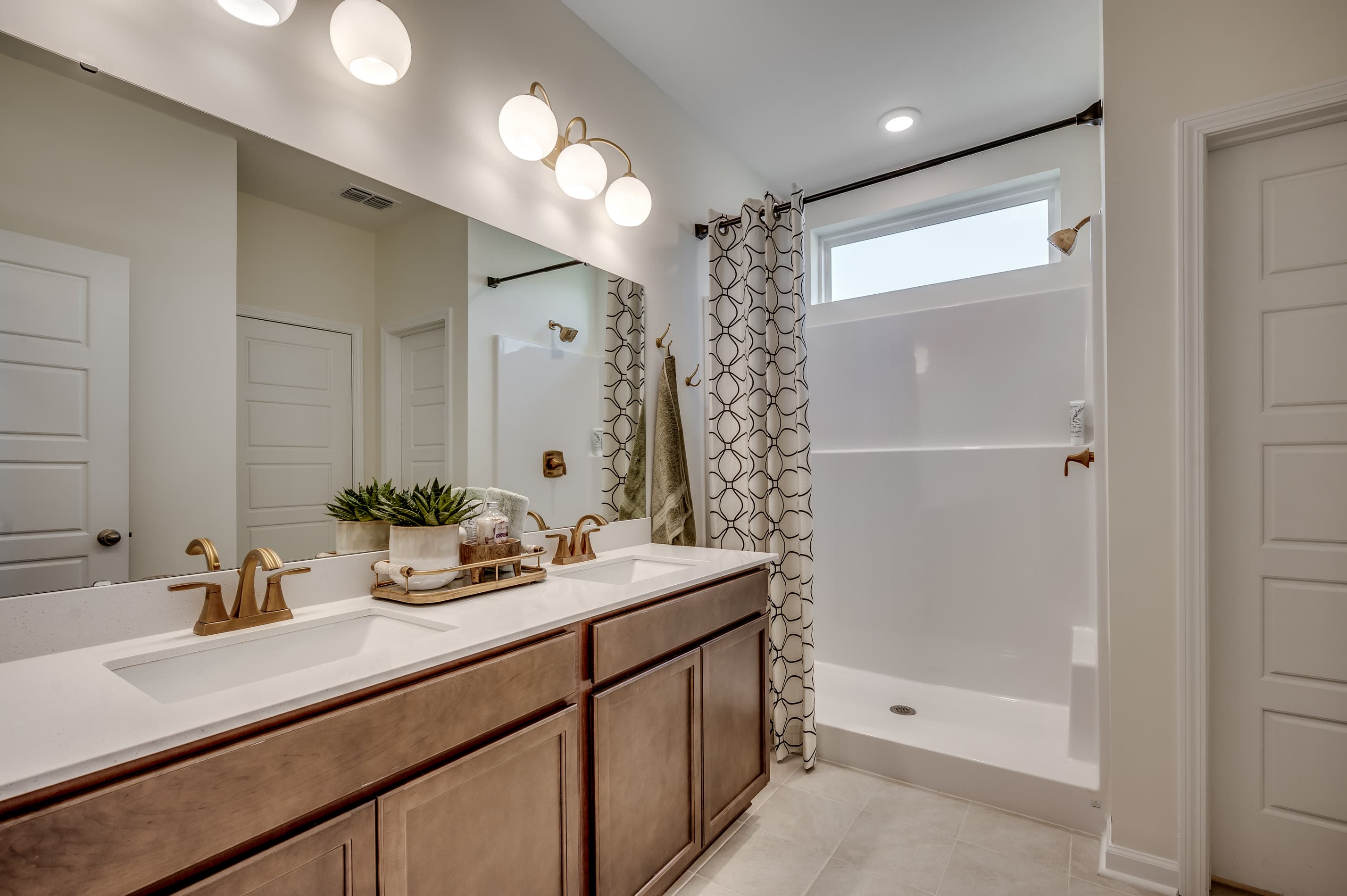 bath with vanity, pendant lights and shower