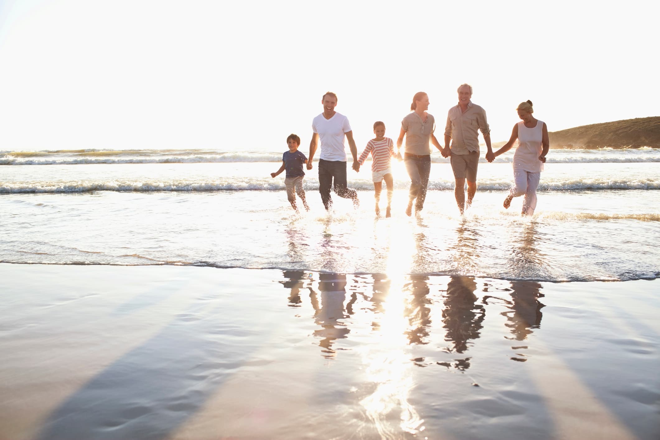 family running through the water at bethany beach