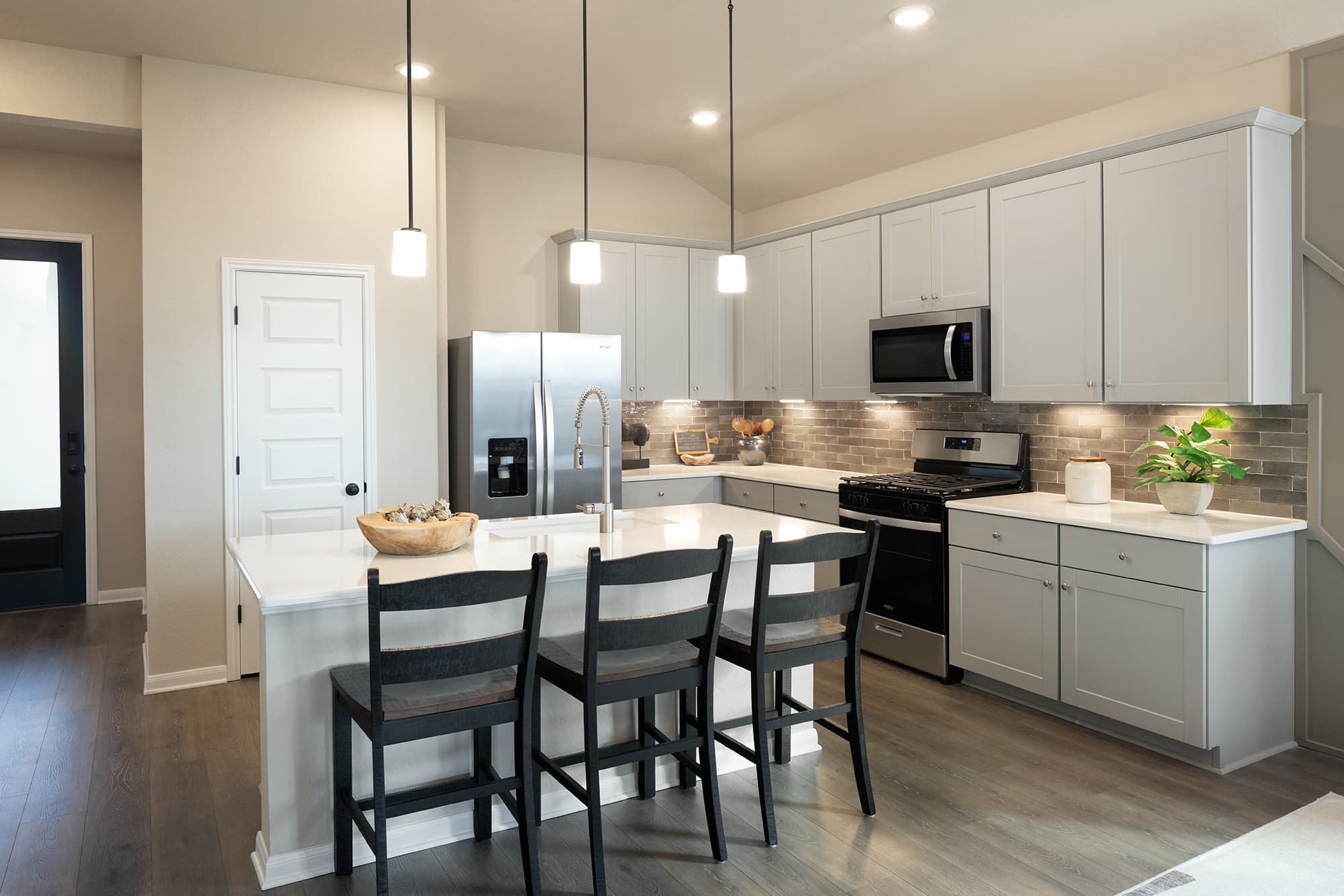 kitchen with white countertops & barstools 