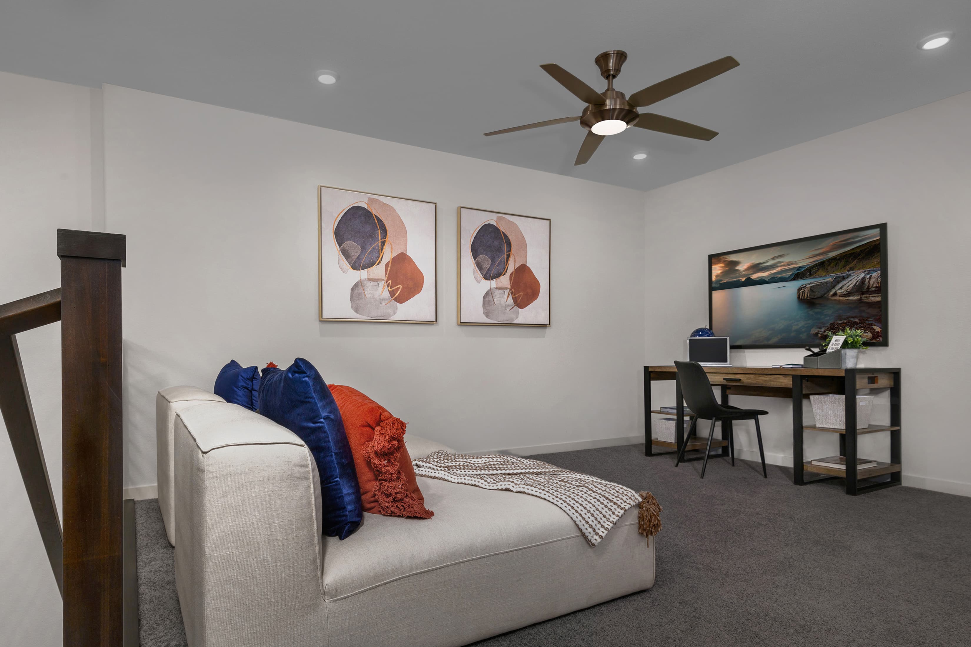 loft with sofa, desk, and chair
