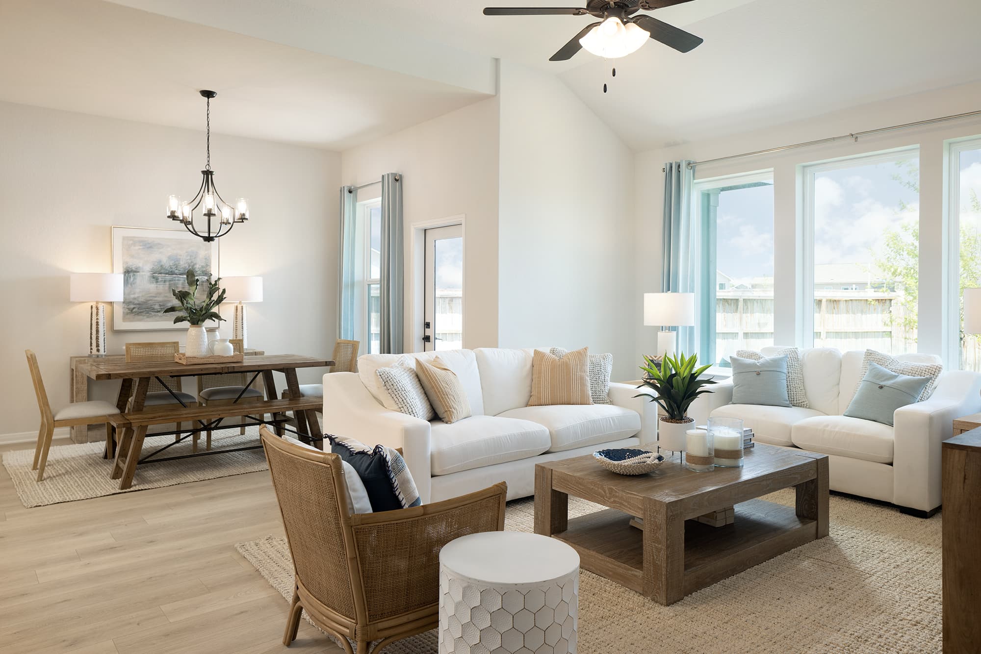 living room with brown flooring, couches & windows
