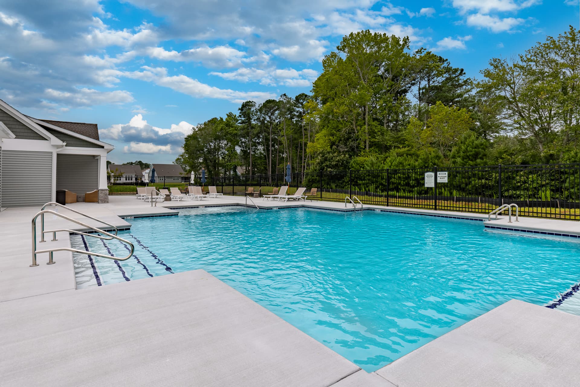 pool with surrounding lounge chairs and tables