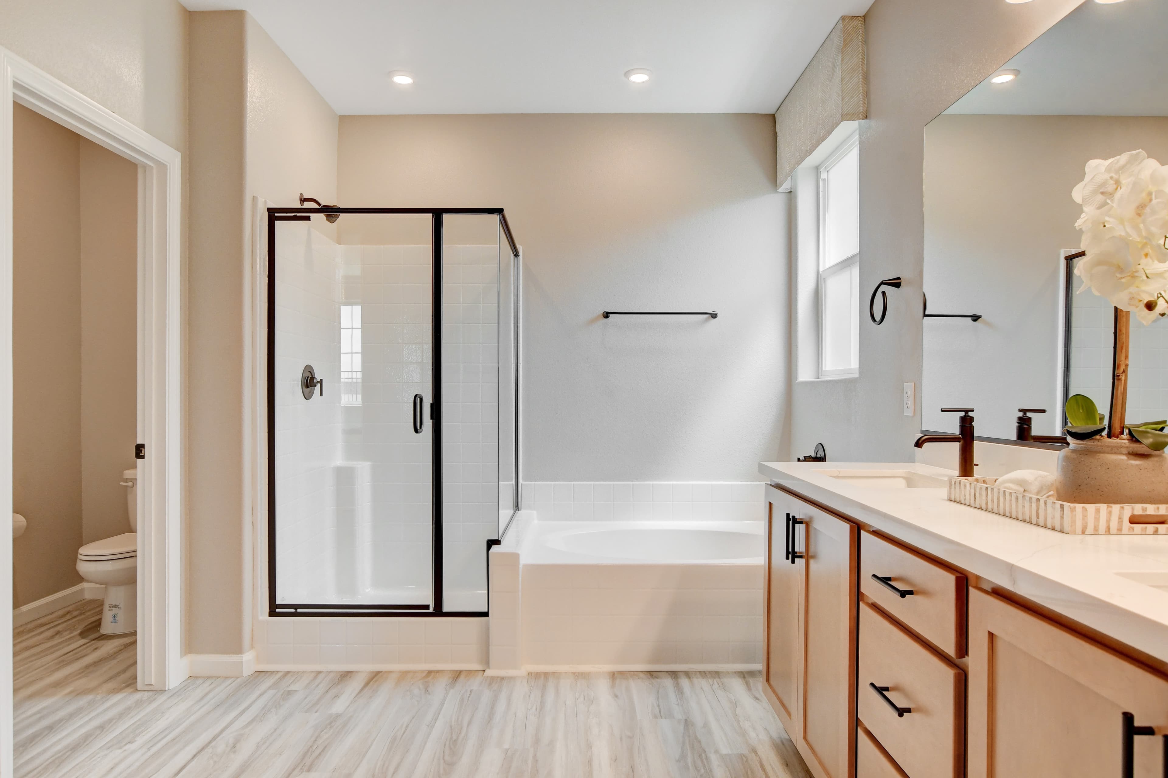 bathroom with tan cabinets and black hardware 