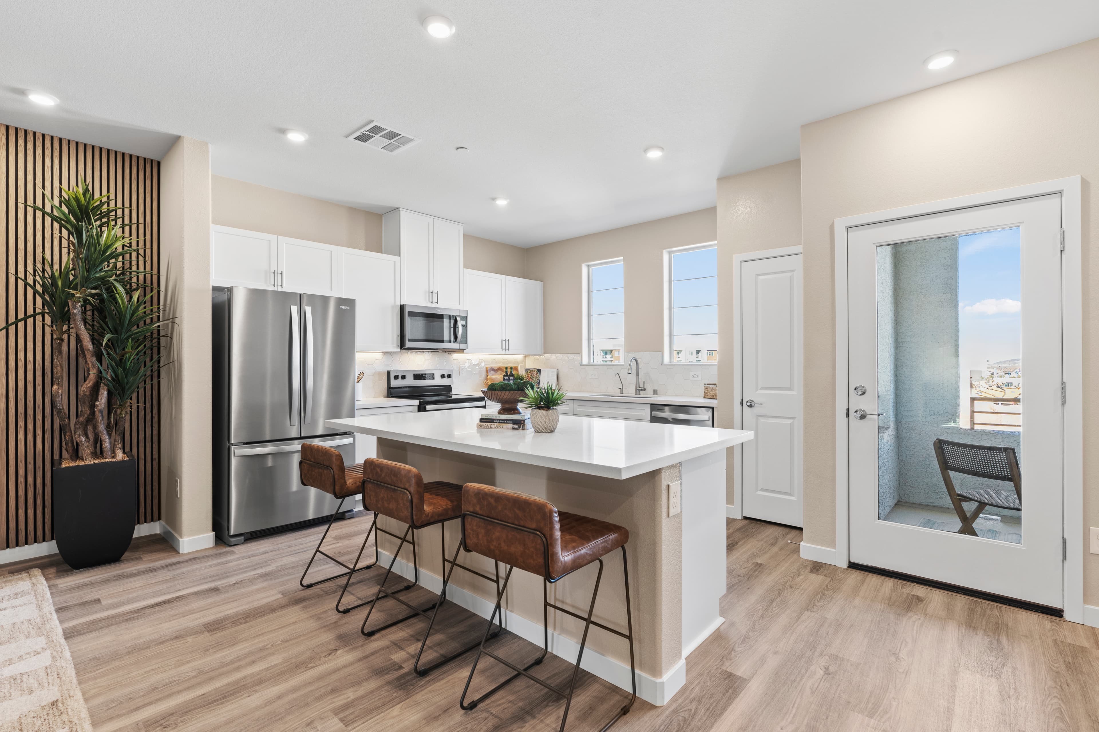 open kitchen with white cabinets and balcony door