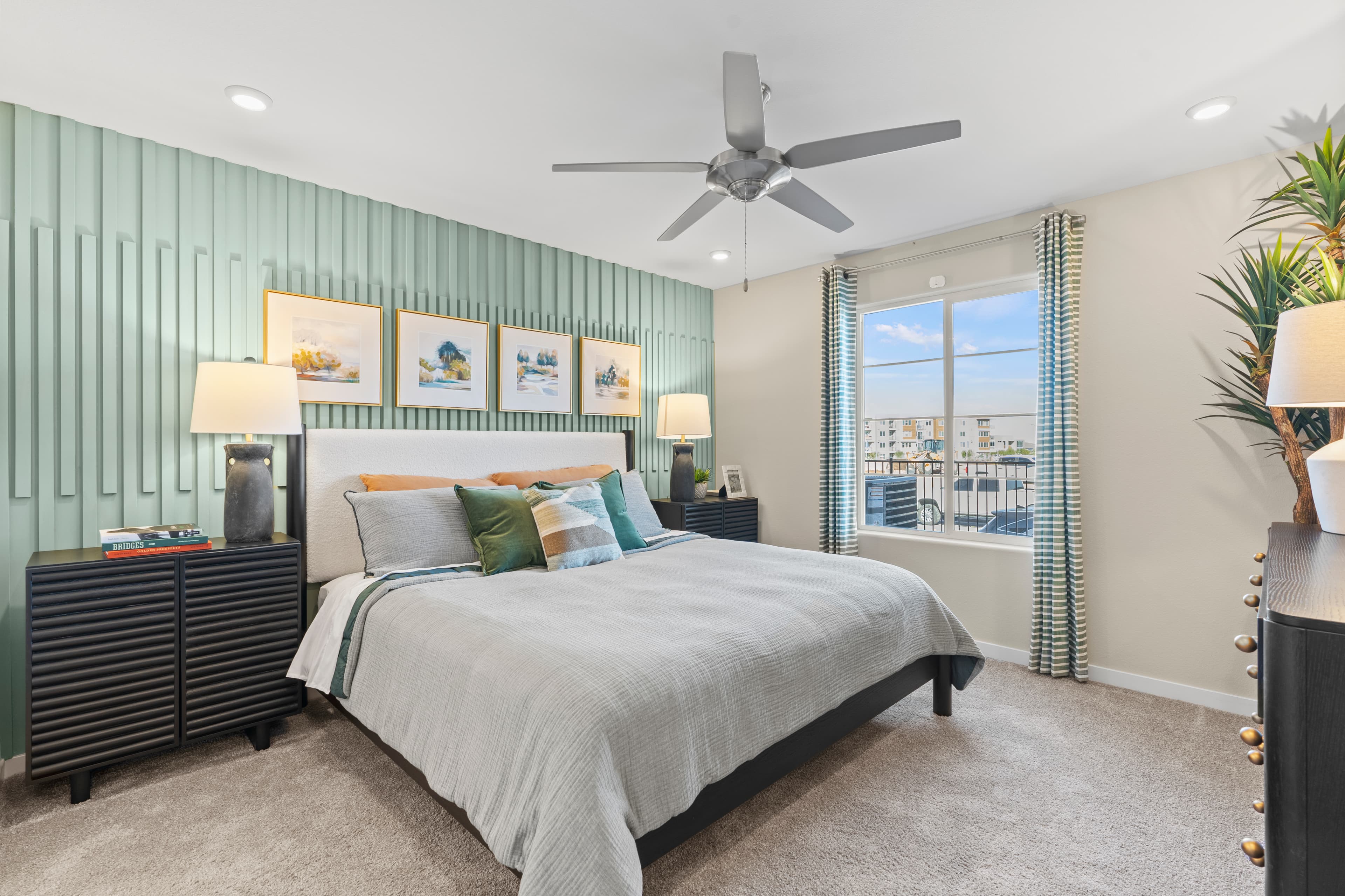 primary bedroom with green accent wall and bed