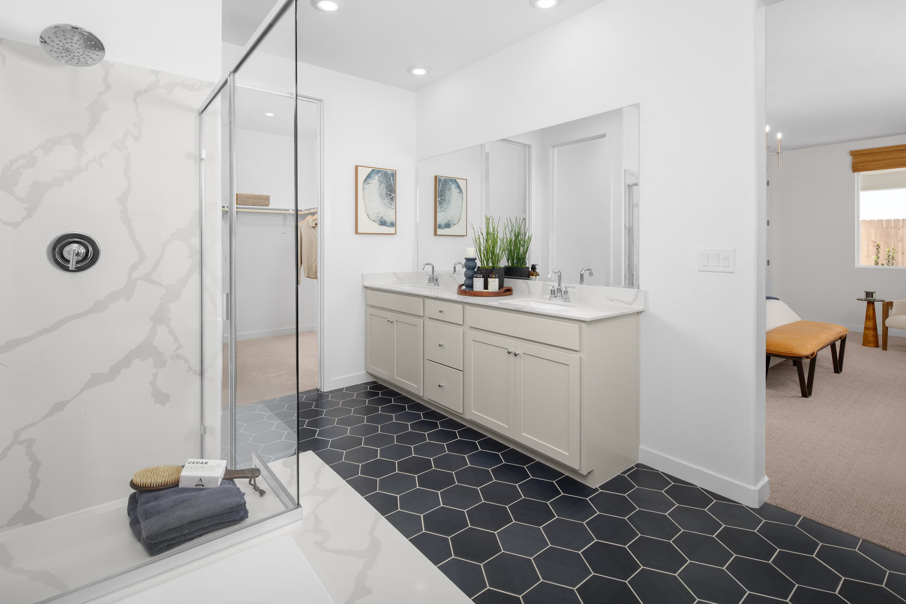 bathroom with navy tile floors and white cabinets