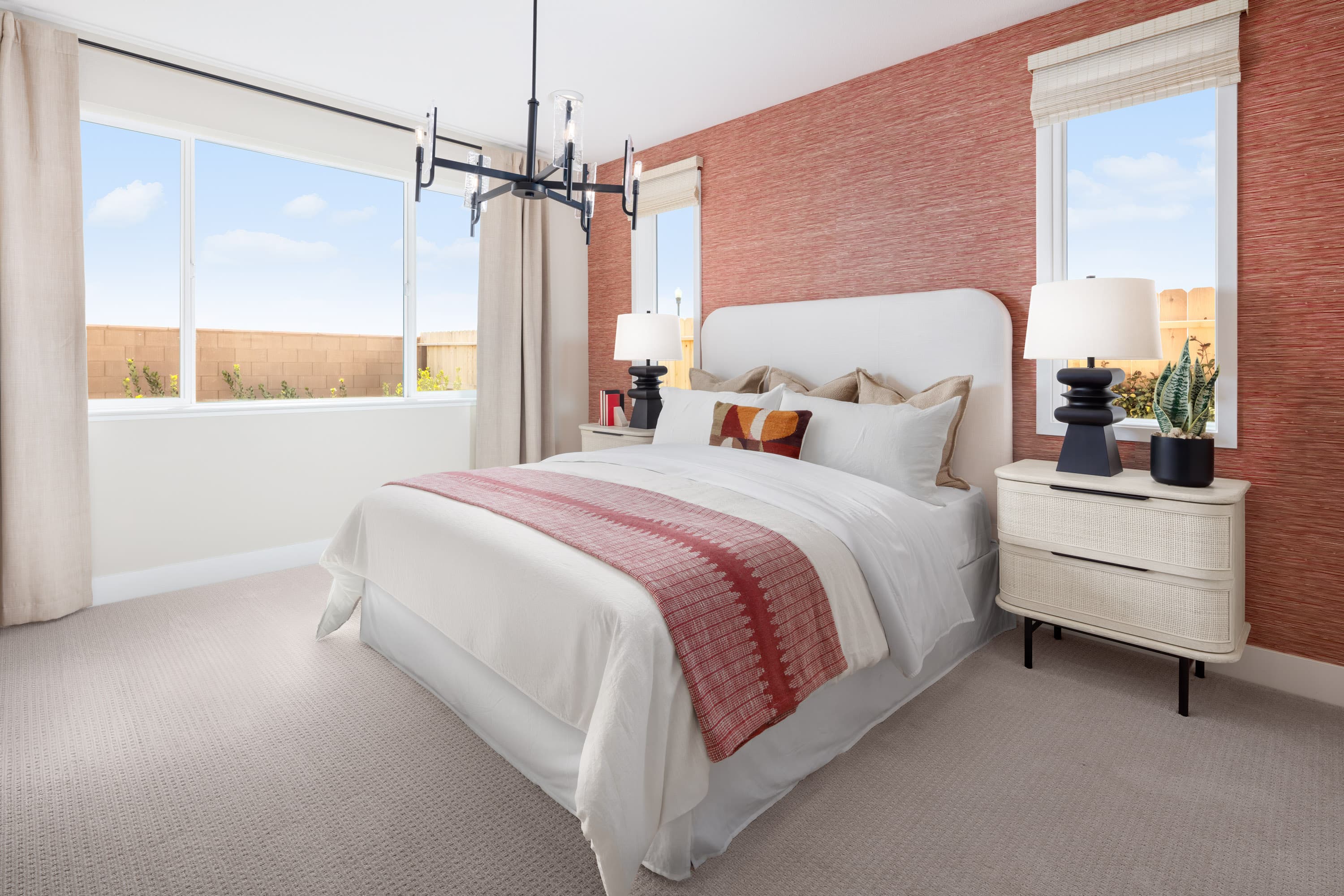 bedroom with burnt orange wallpaper and windows