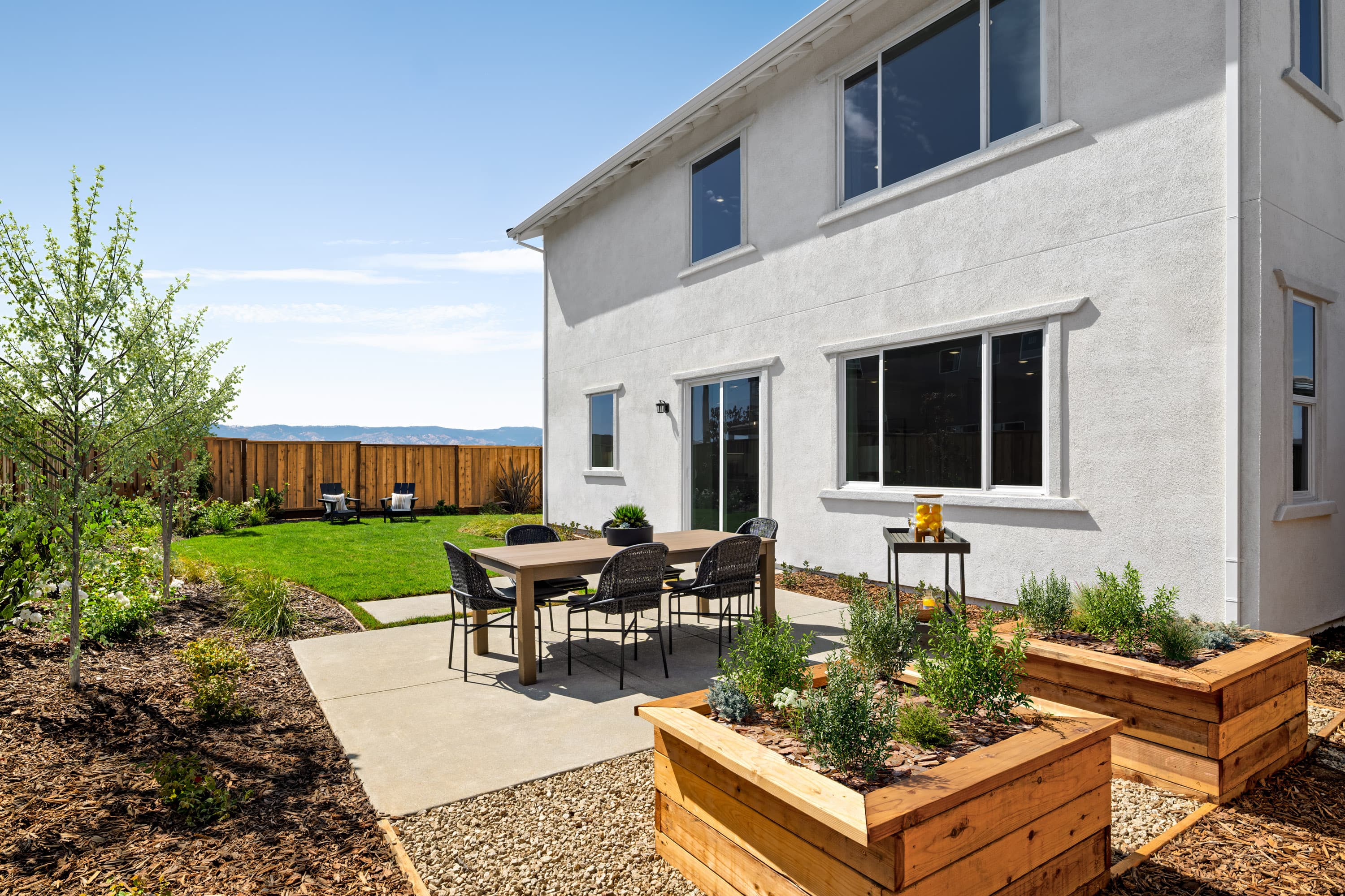 backyard with grassy area & garden beds