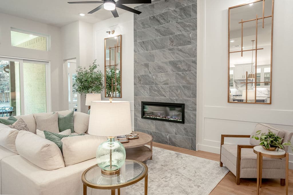 great room with sofa, fireplace and ceiling fan