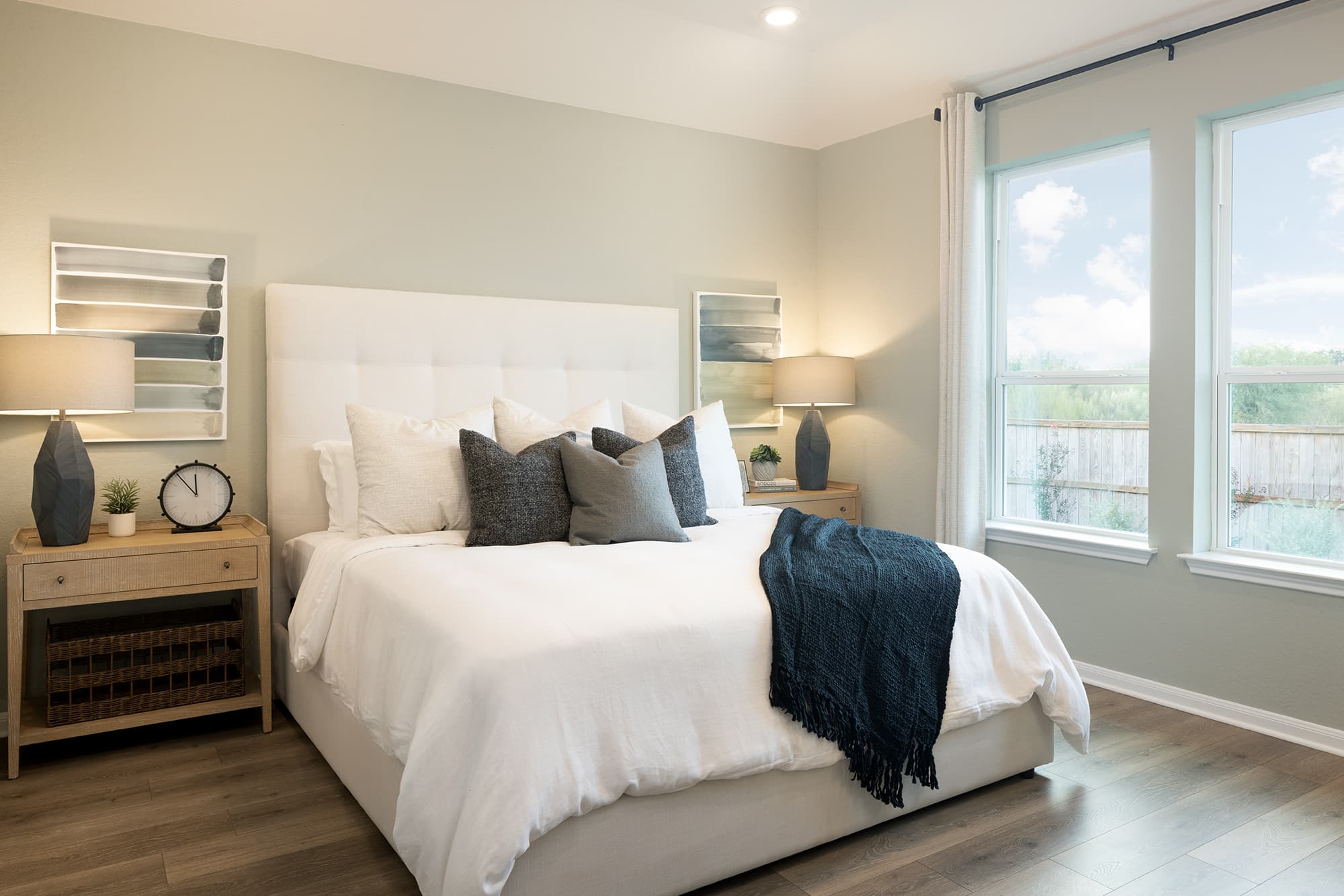 bedroom with brown flooring, windows & ceiling fan