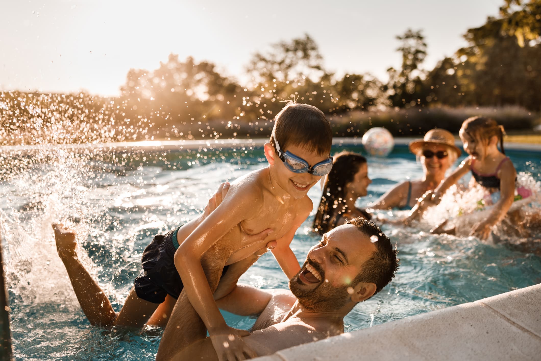 family in pool playing and splashing