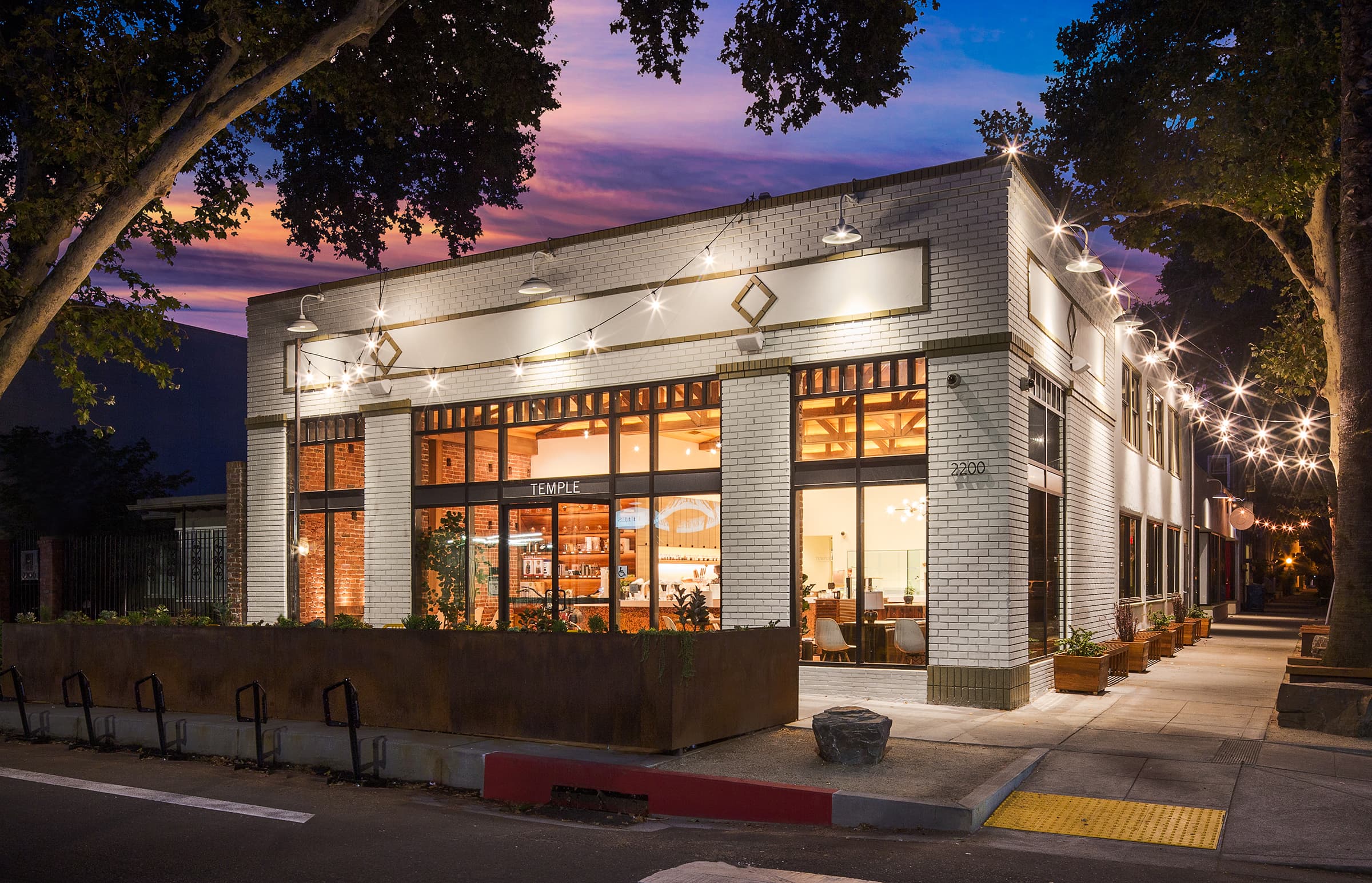 exterior of white brick coffee shop at sunset