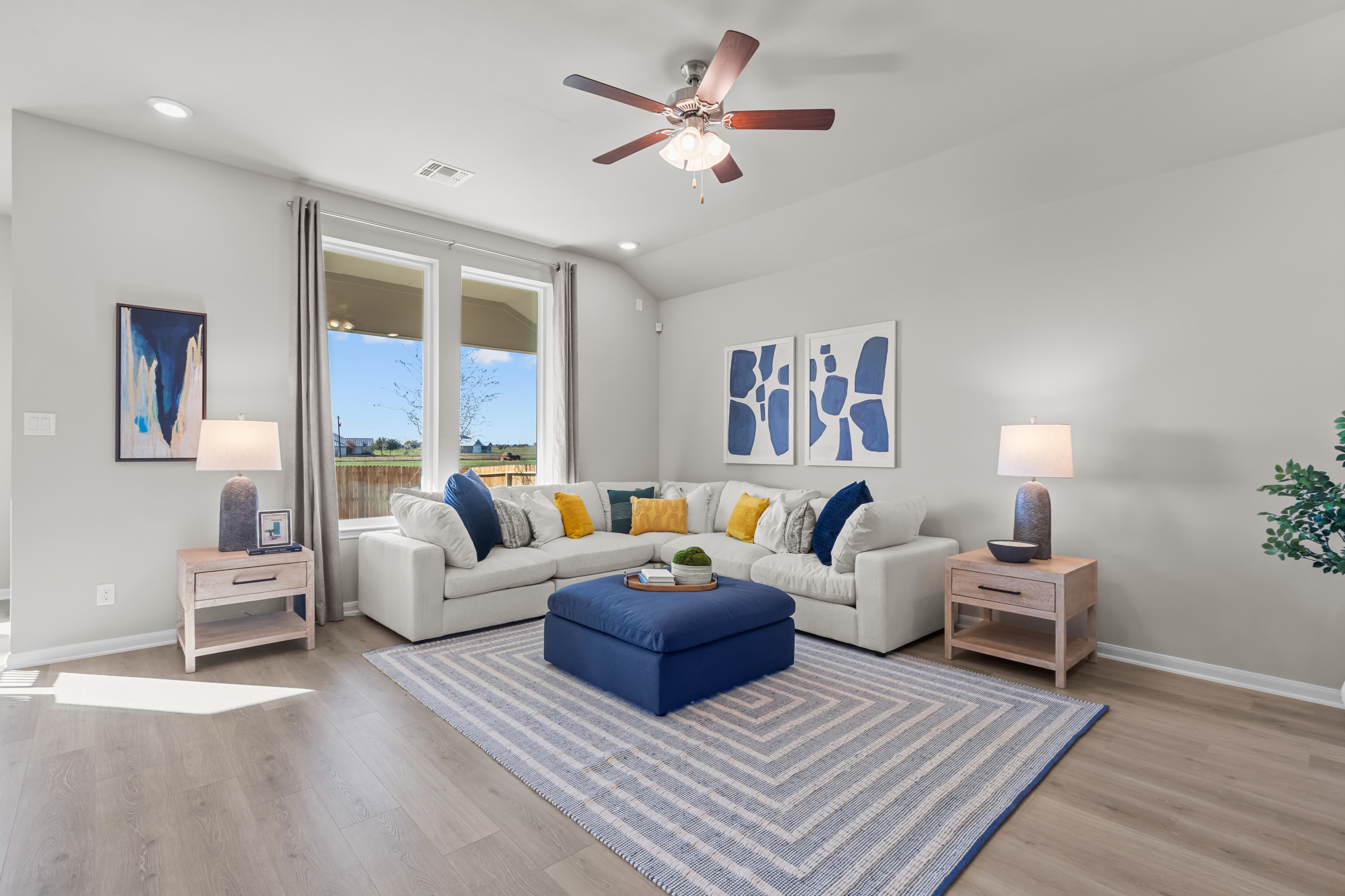 great room with brown flooring, rug & couches 