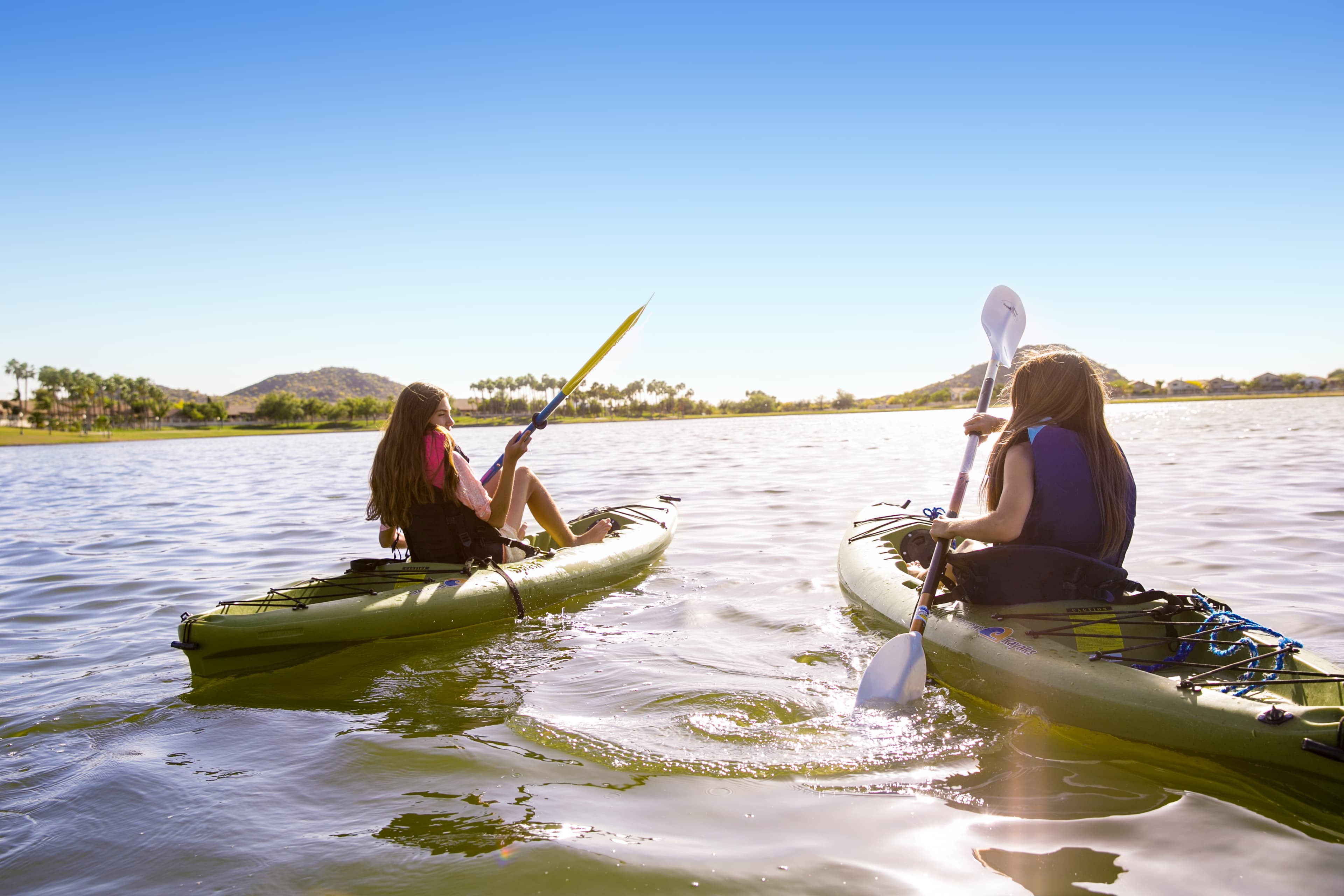 kids on kayaks at community lake