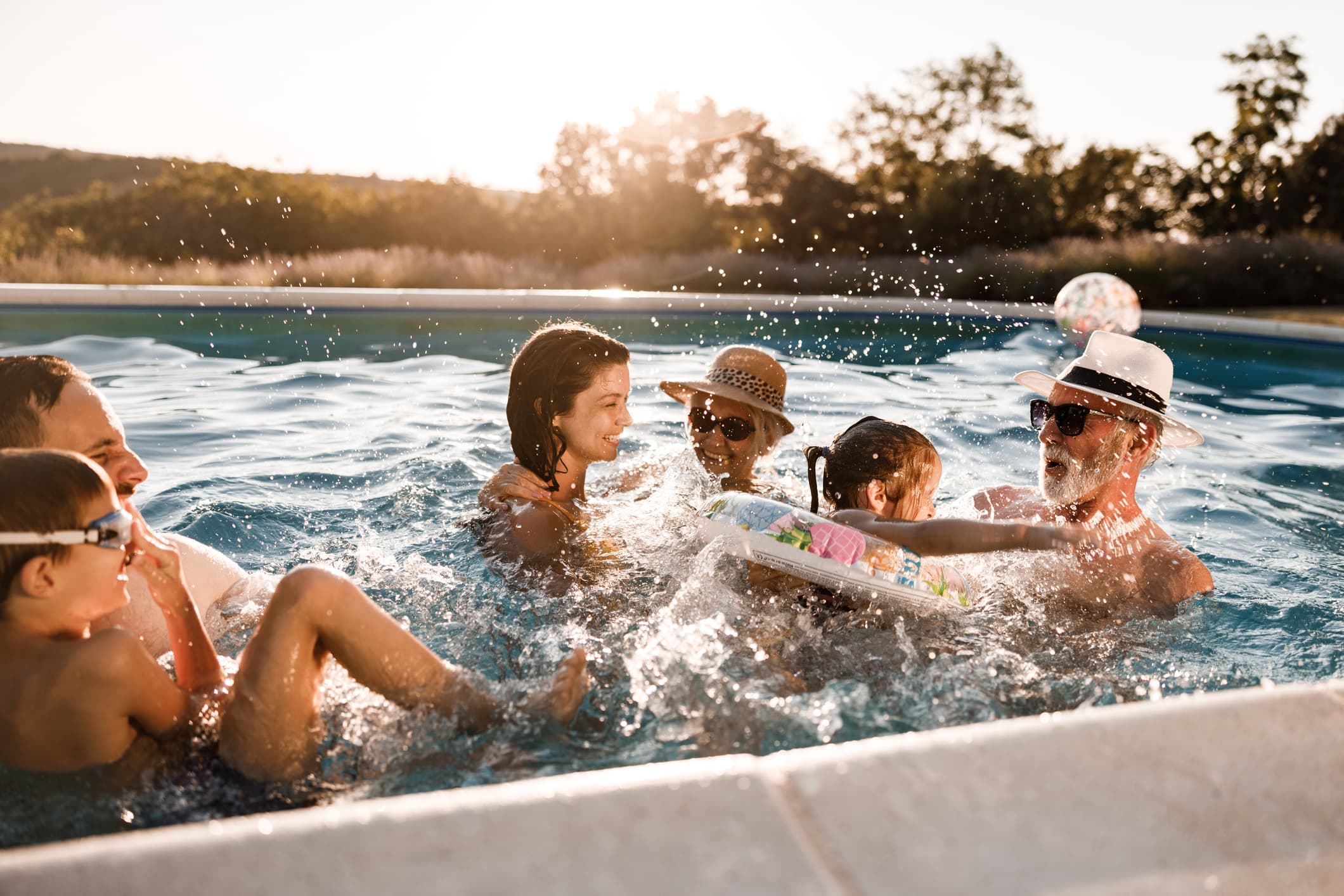 family in pool playing and splashing