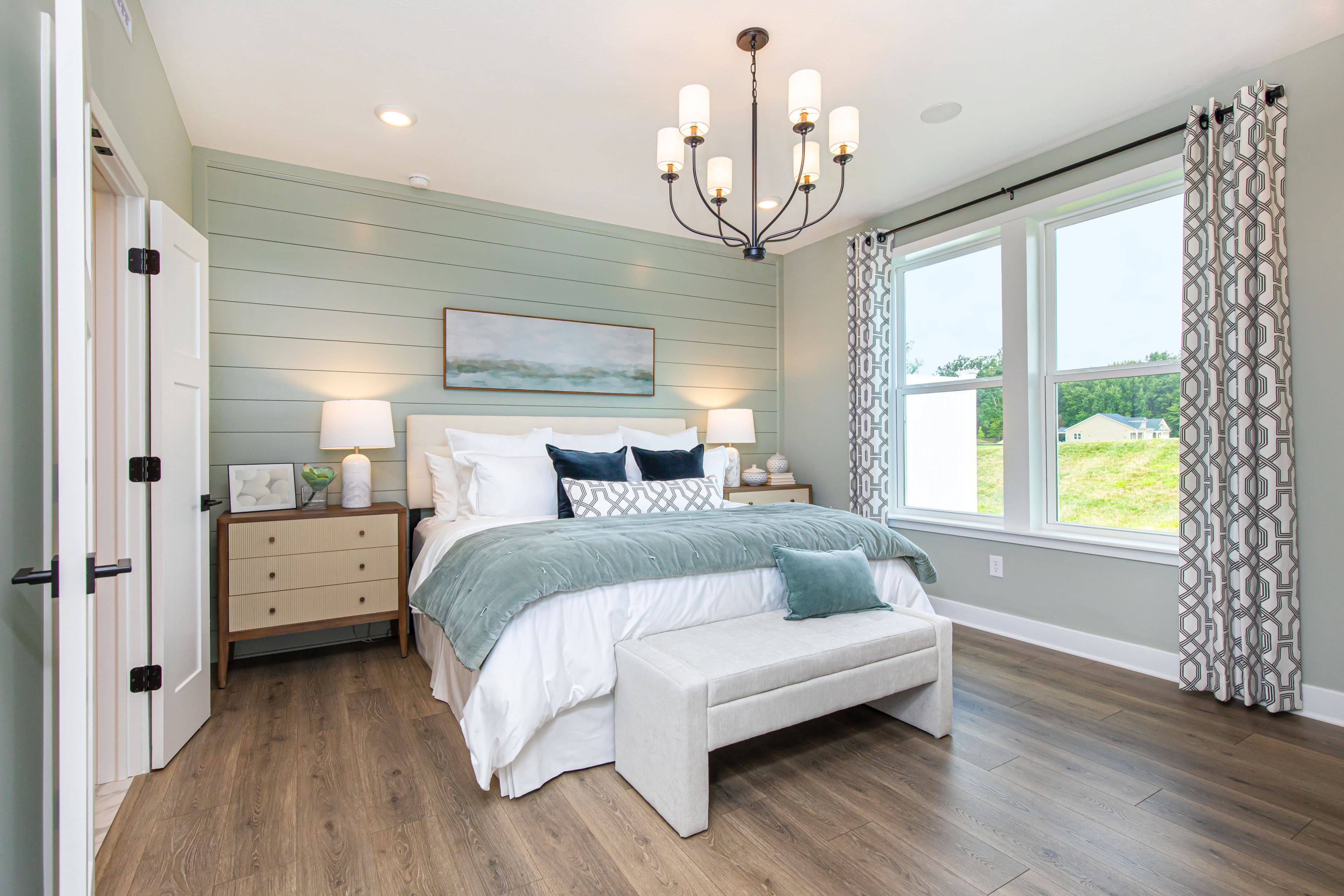 bedroom with wood plank flooring and accent wall