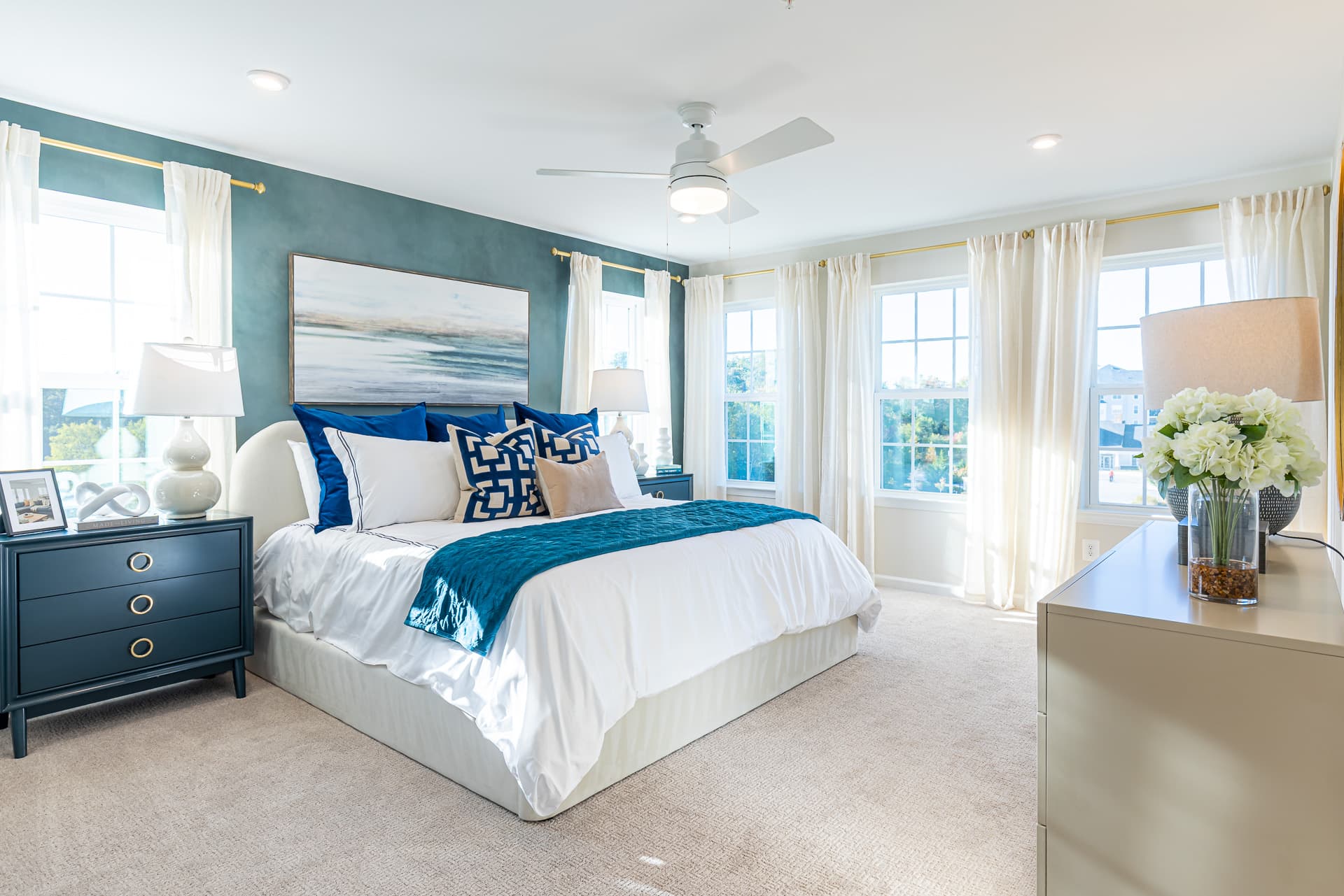 primary suite with carpet and a ceiling fan