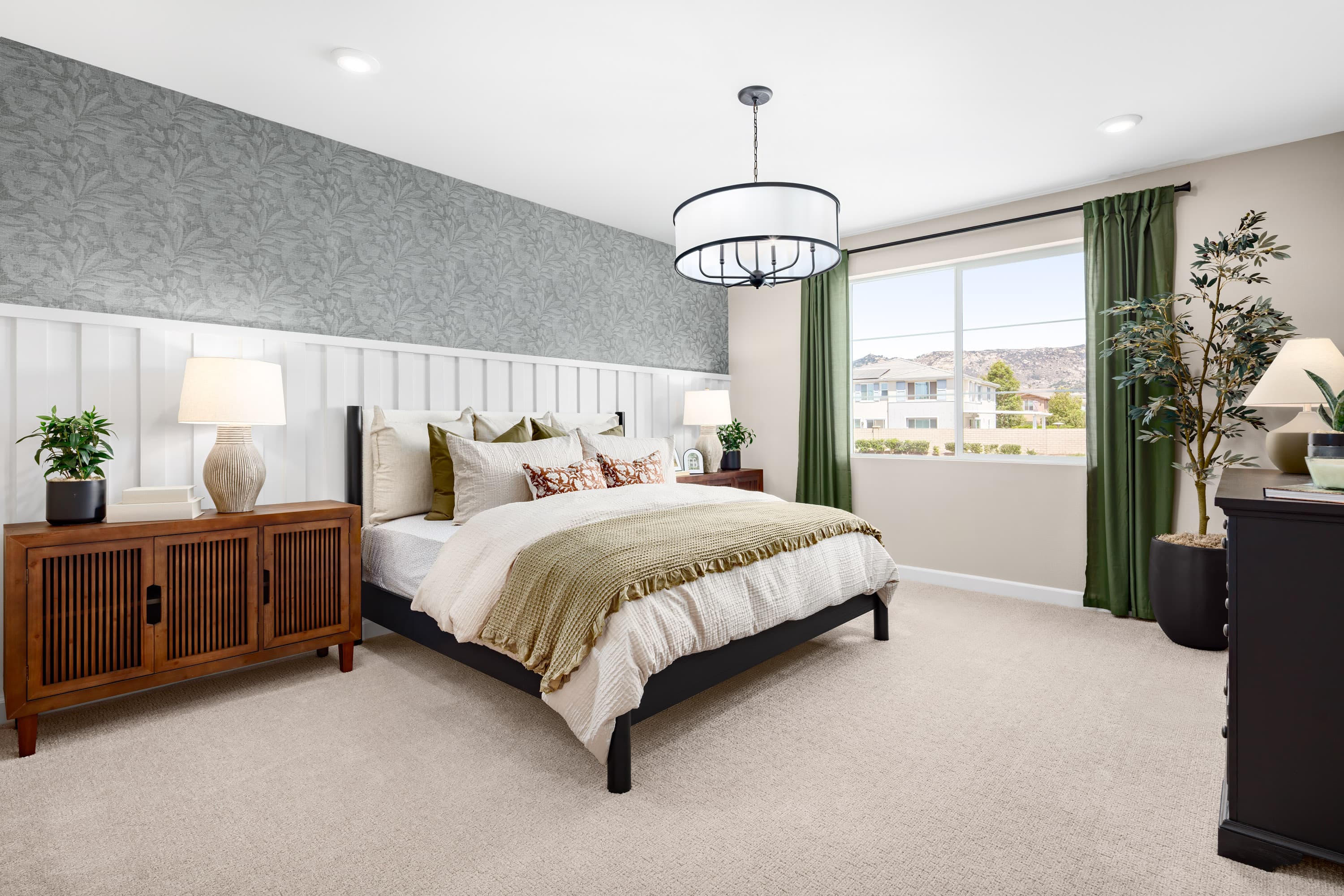 primary bedroom with large bed and dressers