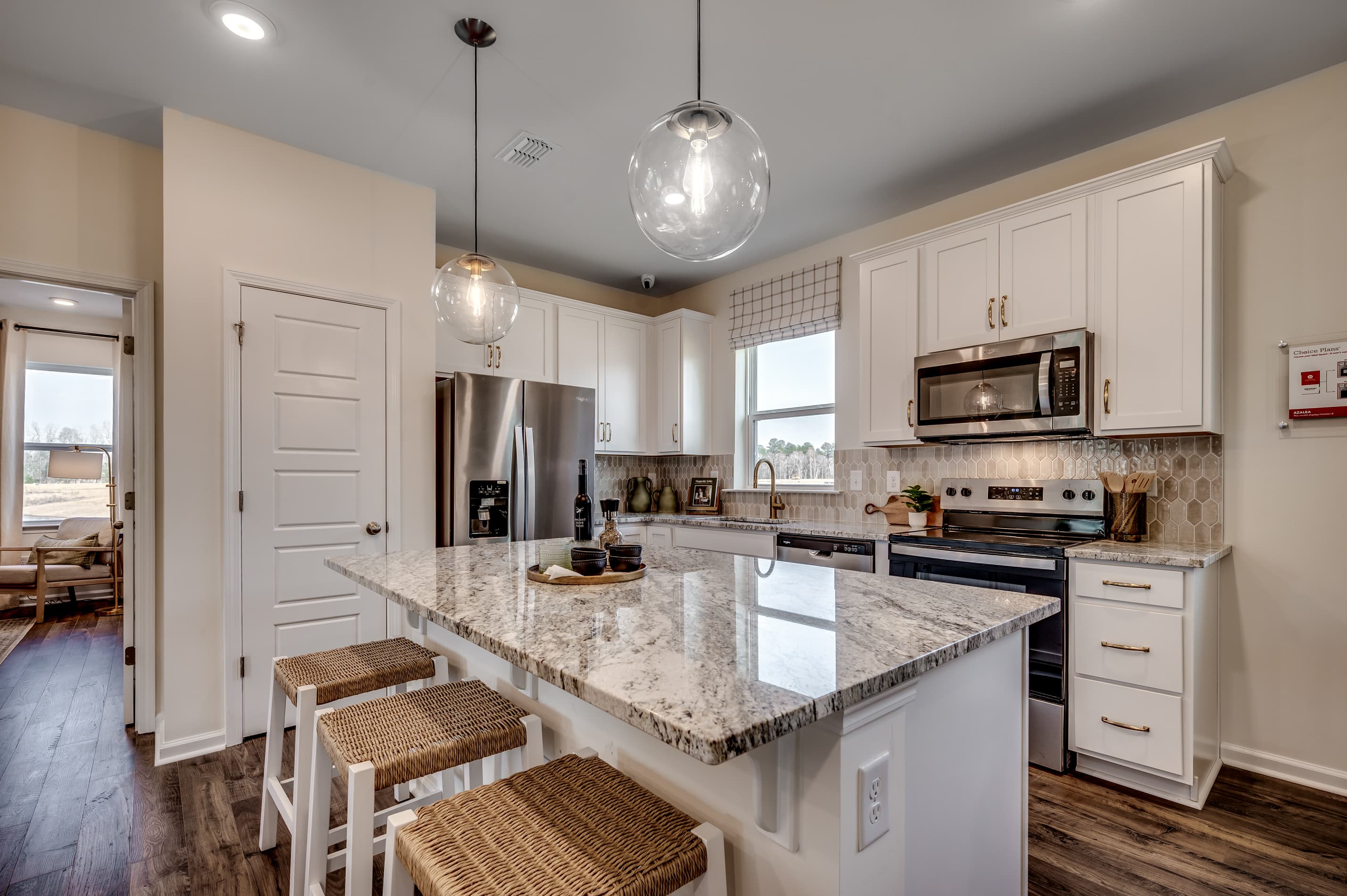 great room with white cabinets and large island