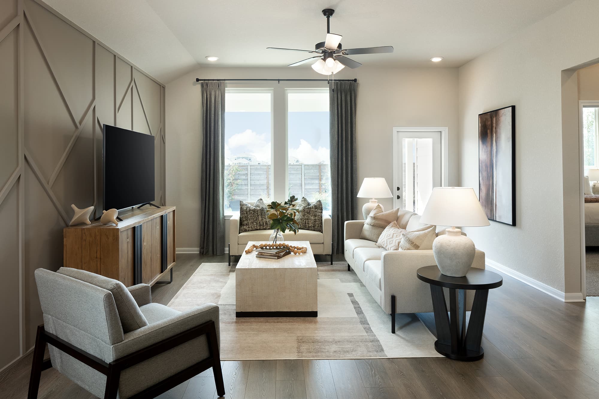 living room with accent wall, white couch & chairs