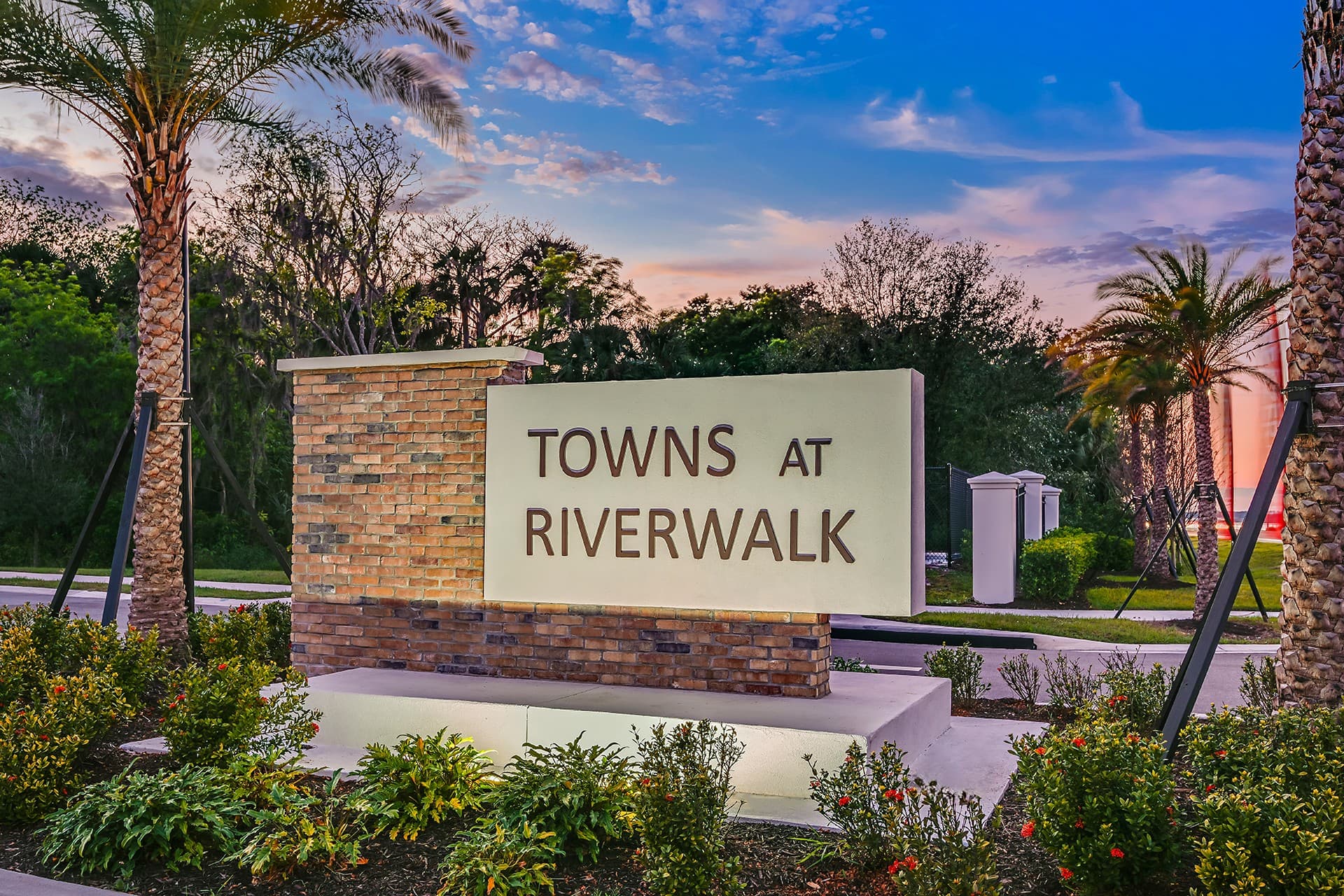 community entrance sign with brick and palm trees