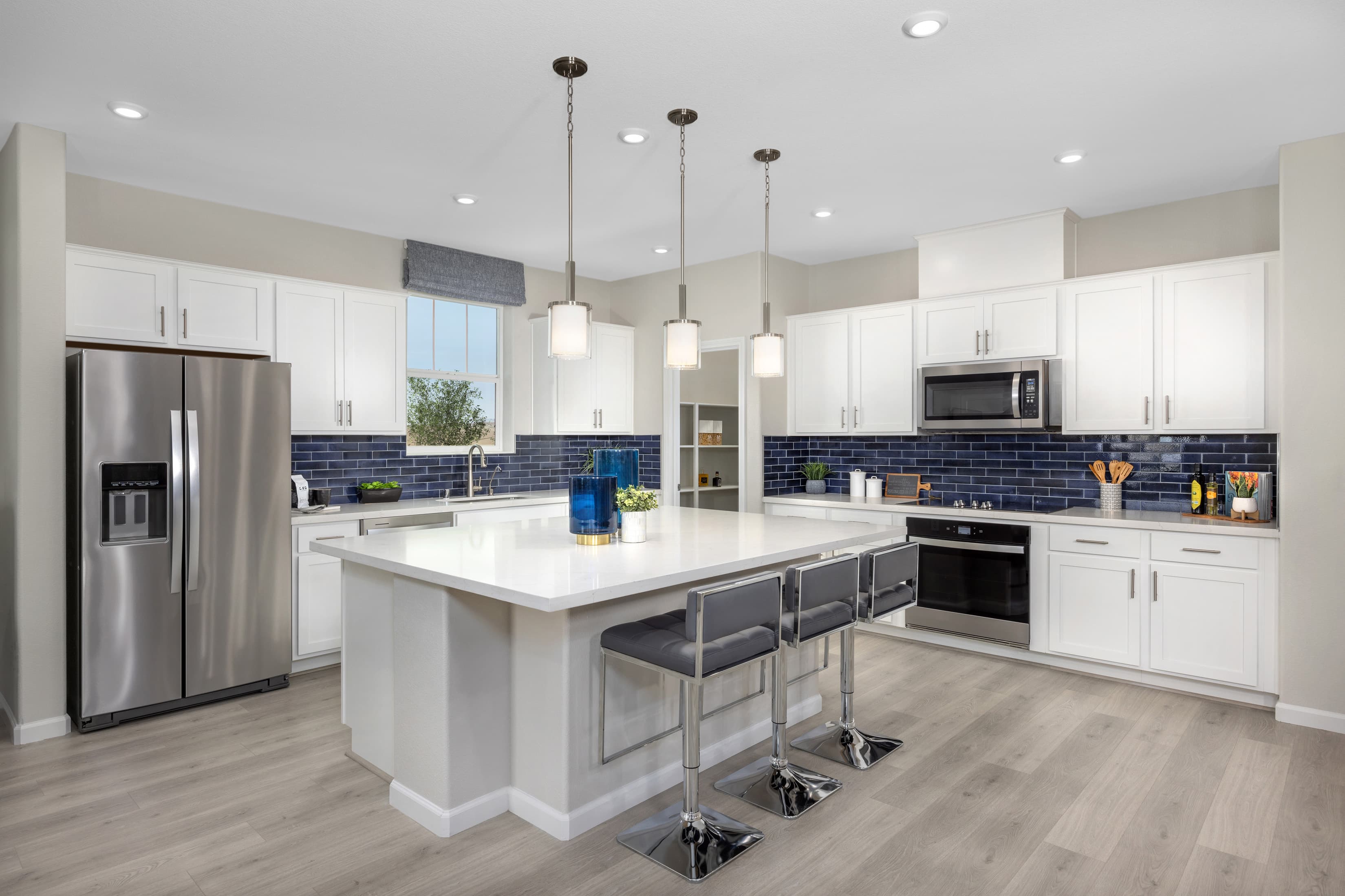 kitchen with blue backsplash and white cabinets