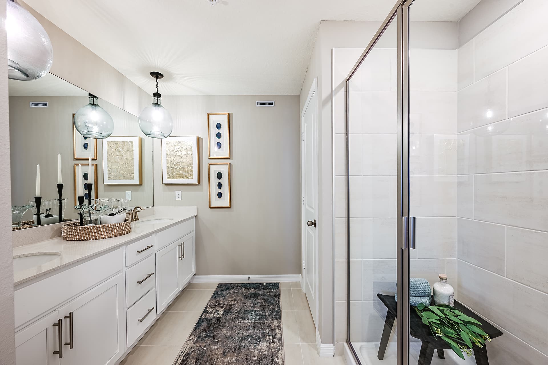 primary bathroom with dual sink vanity and shower