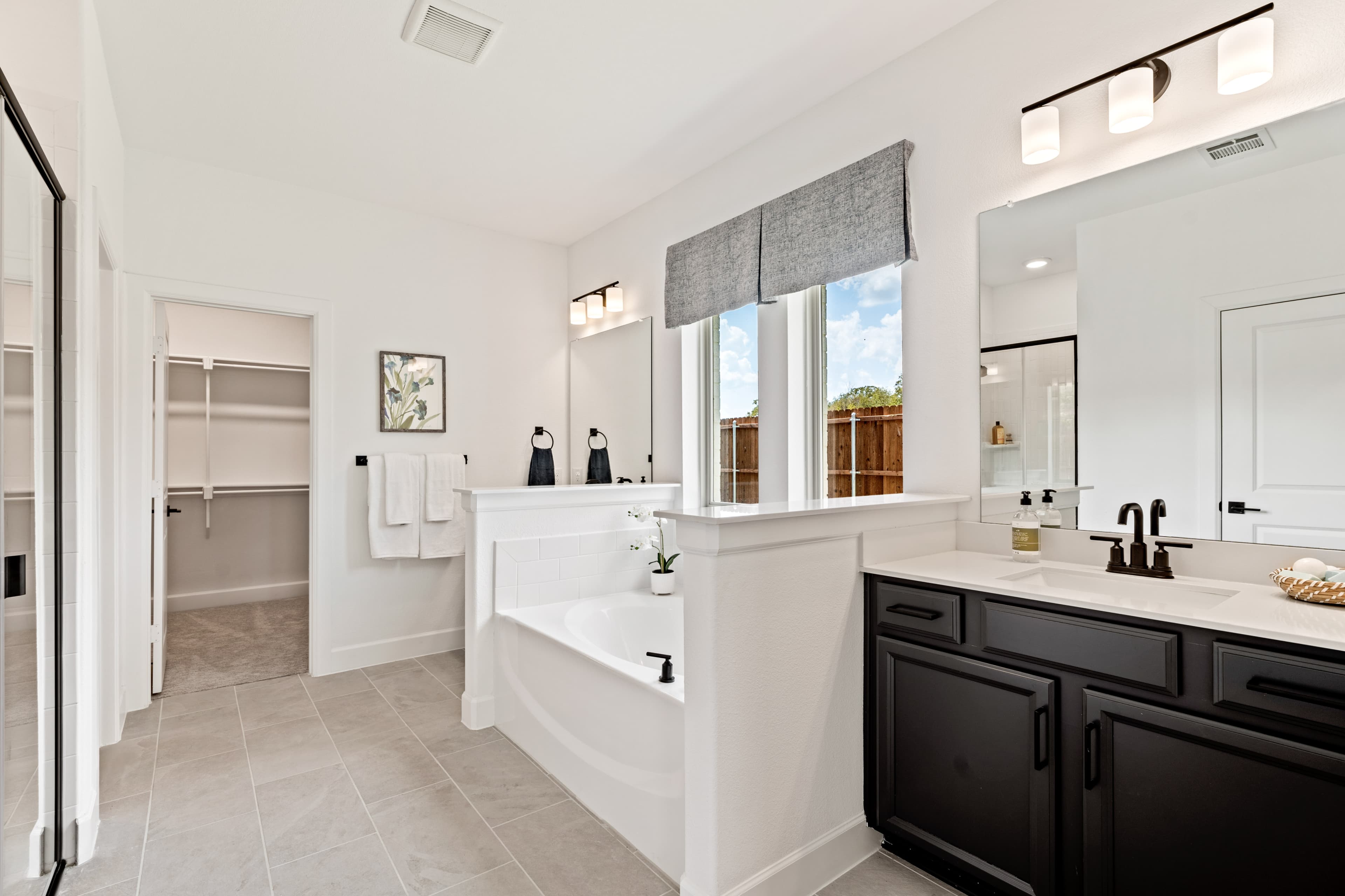 primary bathroom with two sinks and soaking tub 