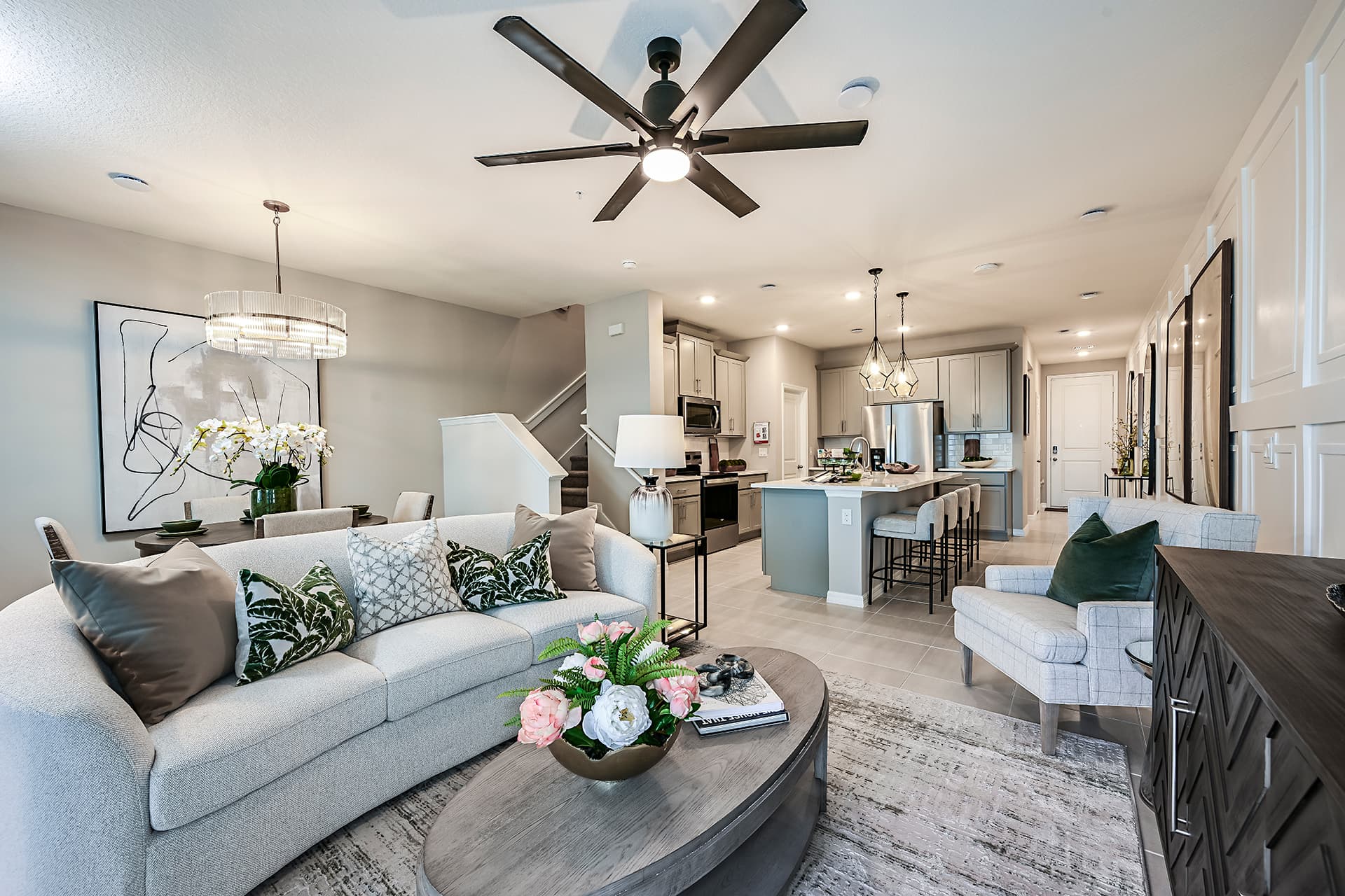 great room with light gray couch and ceiling fan