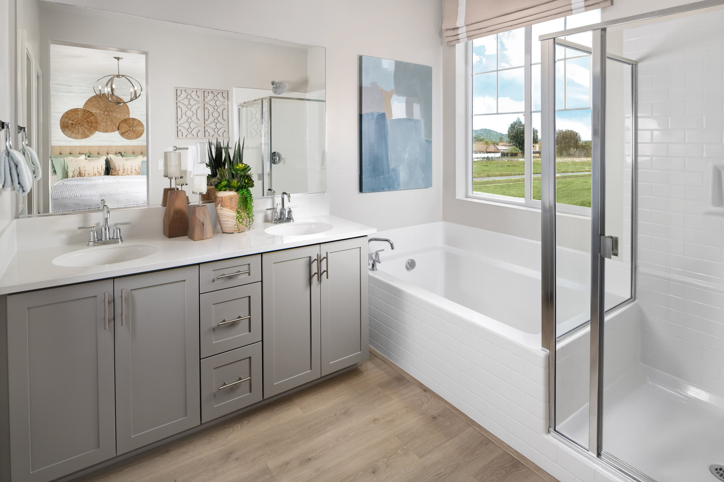primary bathroom with gray cabinets and tub