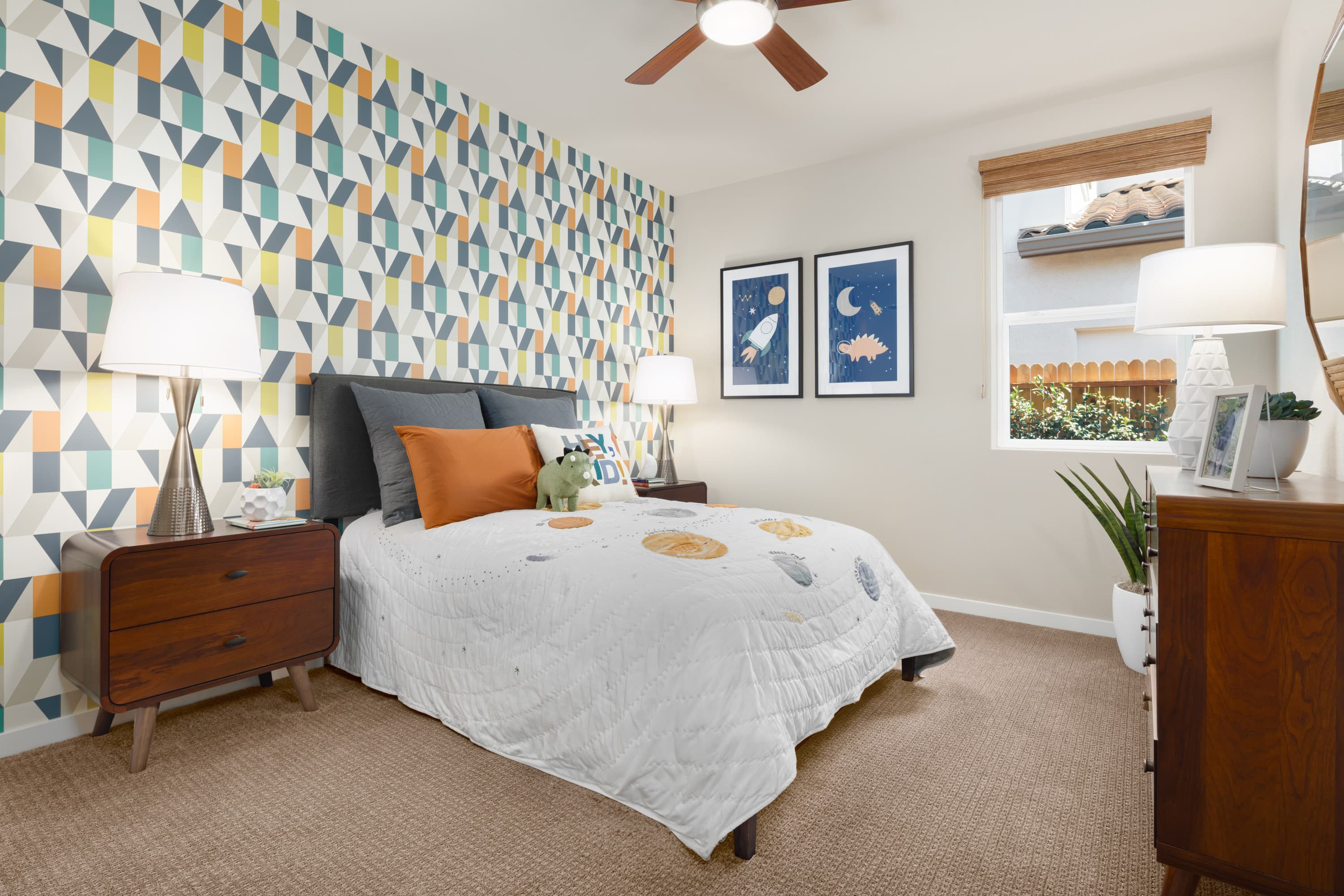 bedroom with colorful patterned wall behind bed