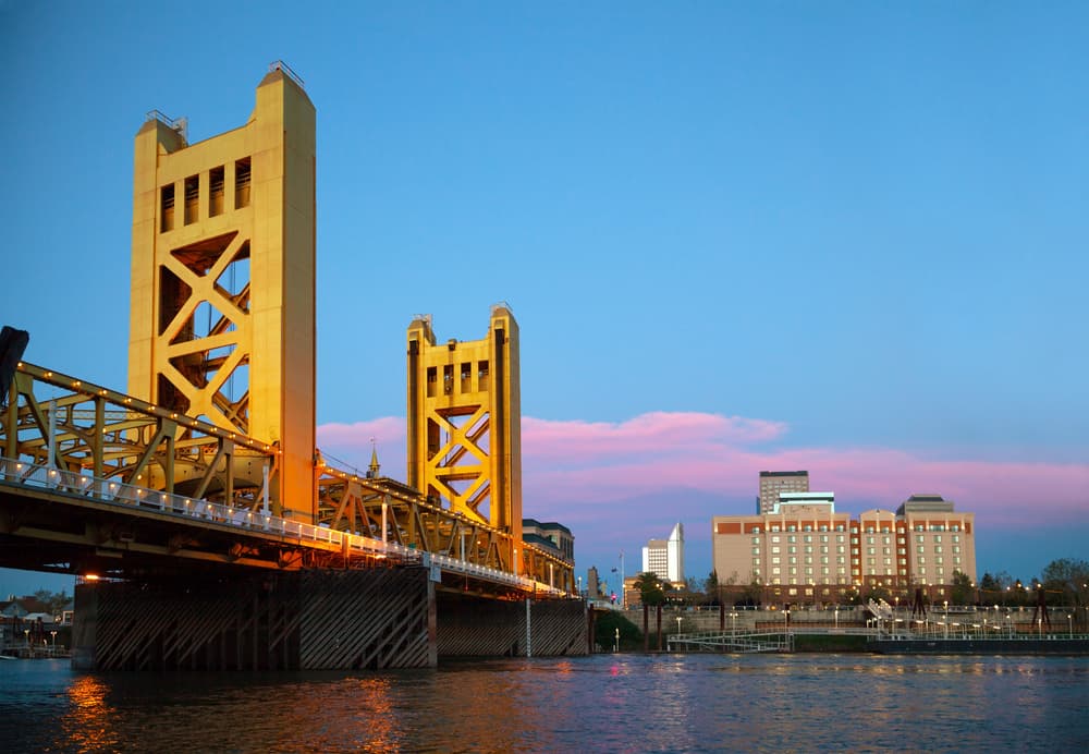 gold bridge over river at sunset